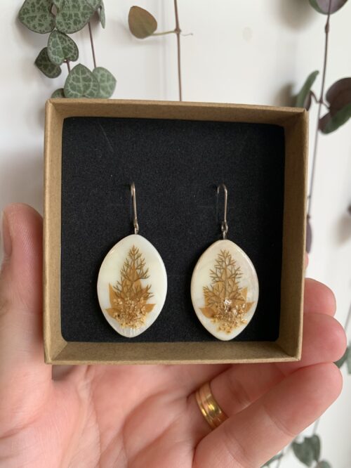 Pendientes ovalados de nácar blanco y plantas verdes