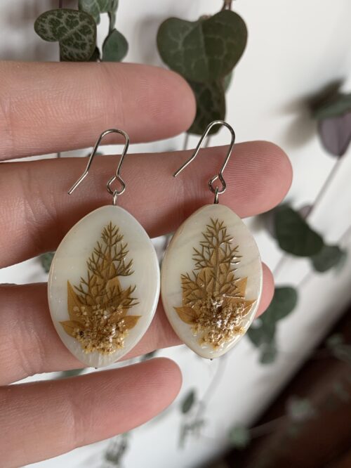 Pendientes ovalados de nácar blanco y plantas verdes