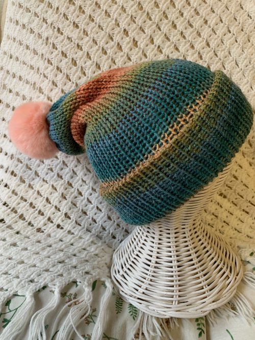 Gorro estilo slouchy artesanal – tonos tierra, verdes y azules con pompón